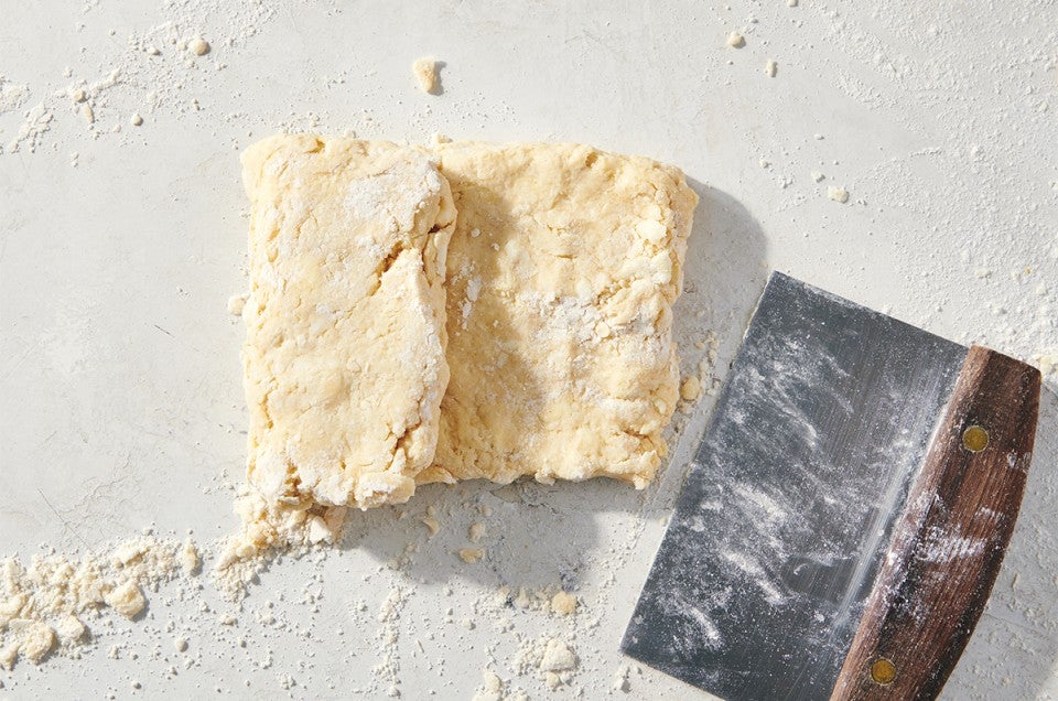 Biscuit dough being folded like a letter